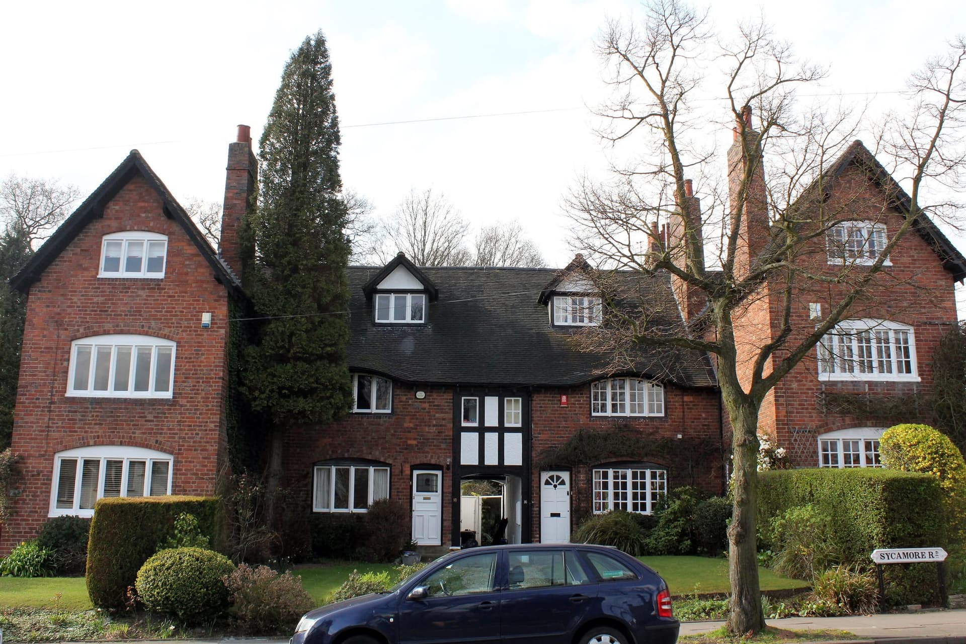 Arts and Crafts brick houses with steep tiled roofs and dormers on Sycamore Road, Bournville