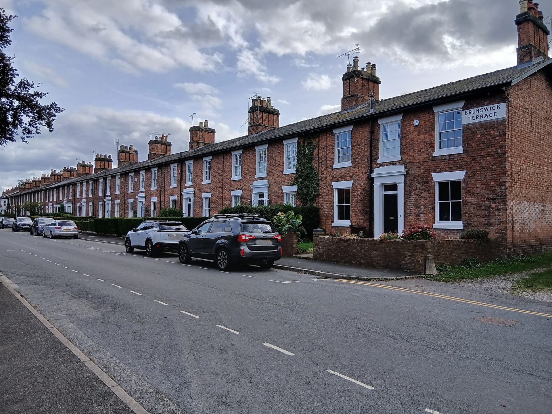 Long 19th-century red brick terrace with slate roofs and chimney stacks on Brunswick Terrace, Stafford