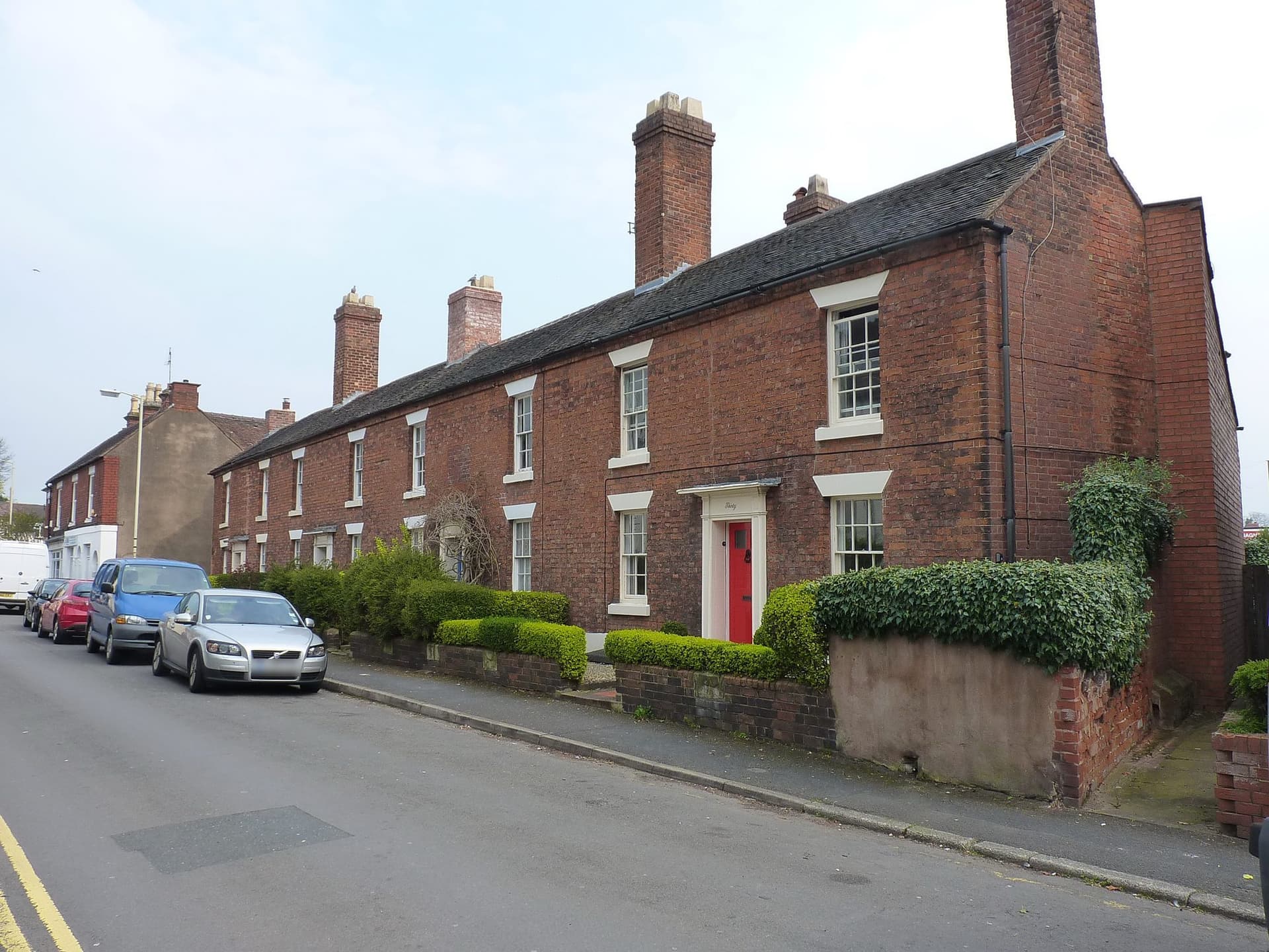 Two-storey red brick terraced houses with a slate roof and tall chimneys at 30 to 36 Park Street, Wellington, Telford