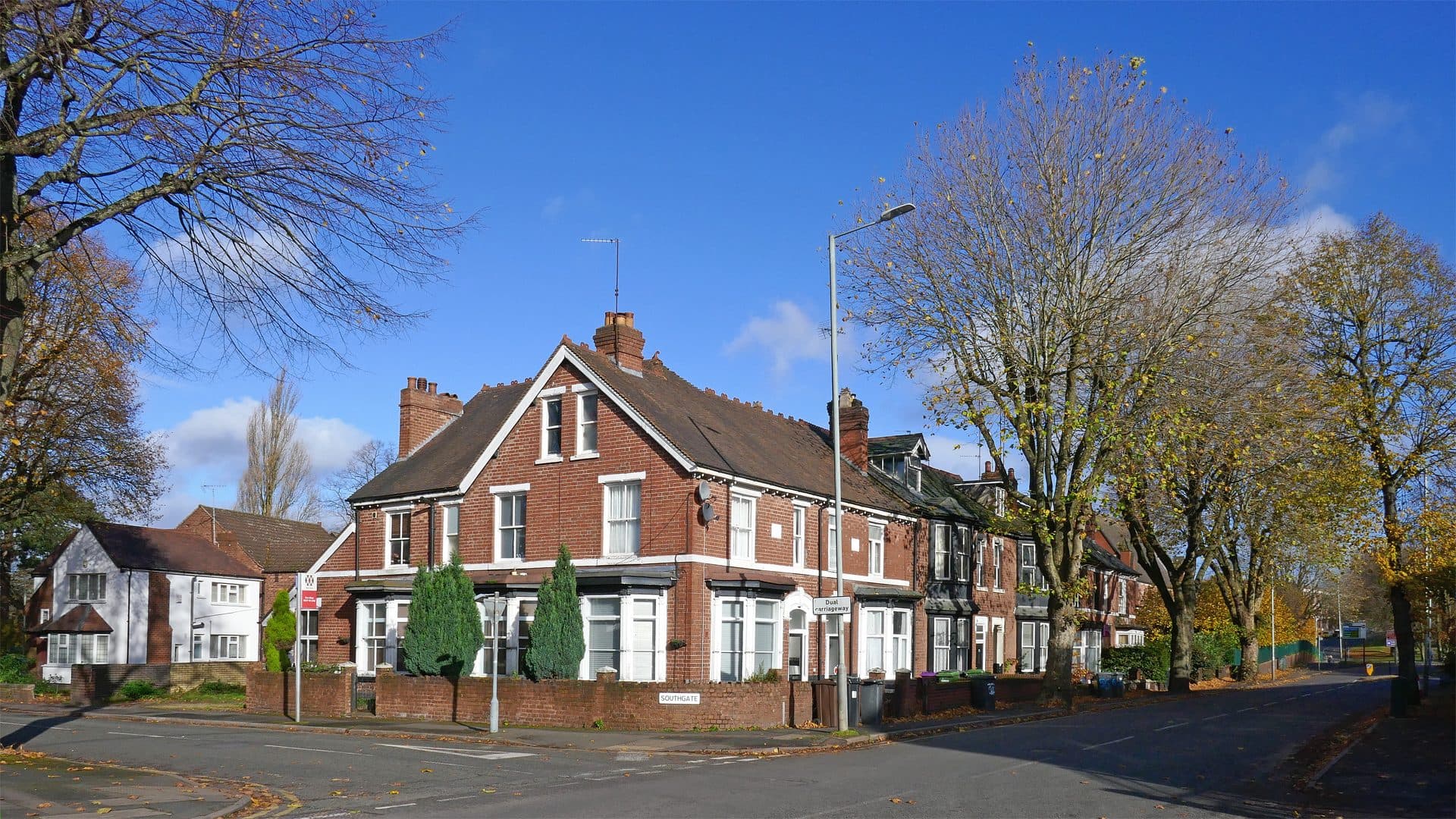 Late Victorian red brick houses with steep tiled roofs, front gables and attic windows on Bath Road at the corner of Southgate, Wolverhampton