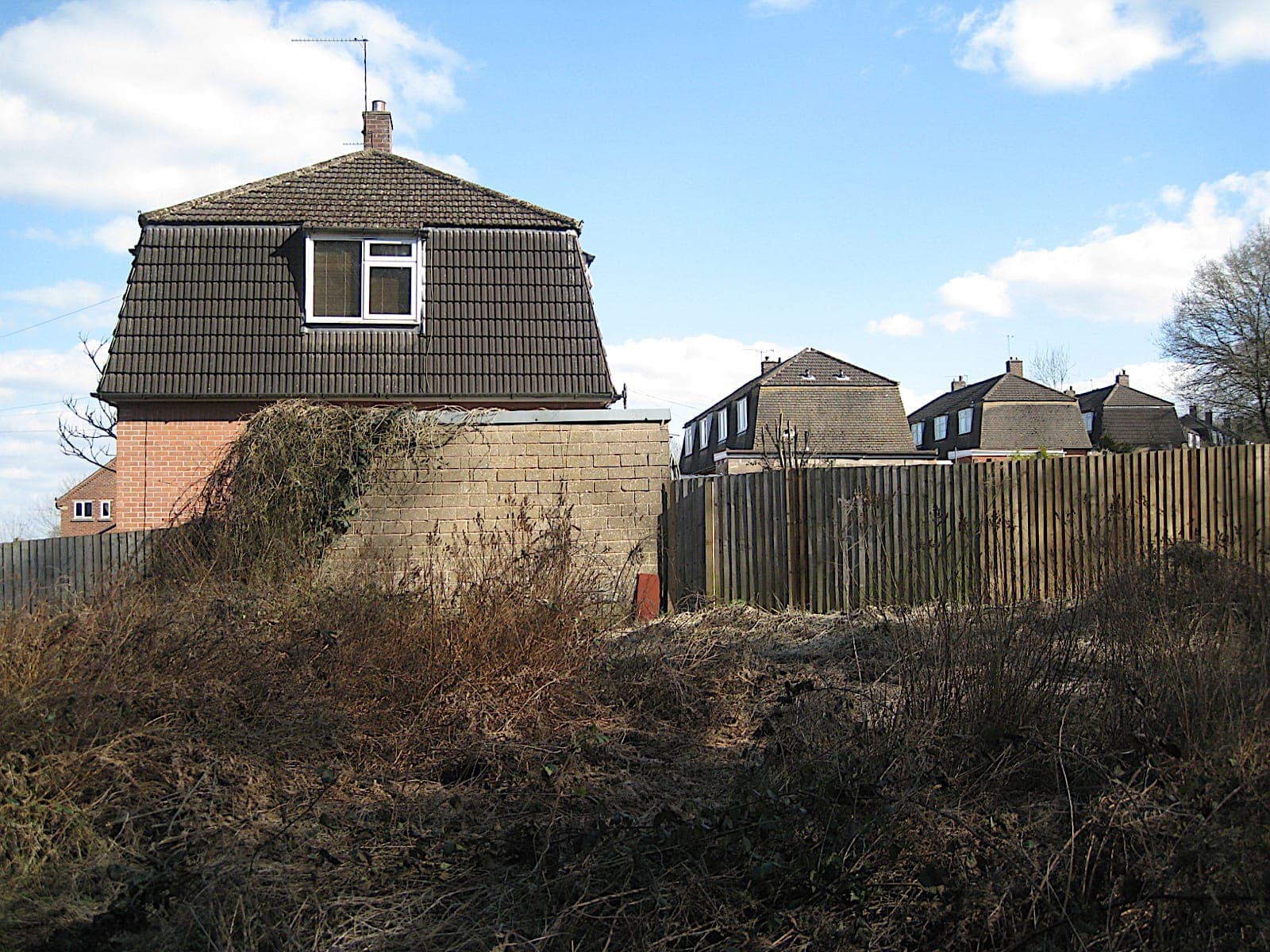 Houses with steep mansard roofs and a dormer window in Pine Tree Close, Batchley, Redditch