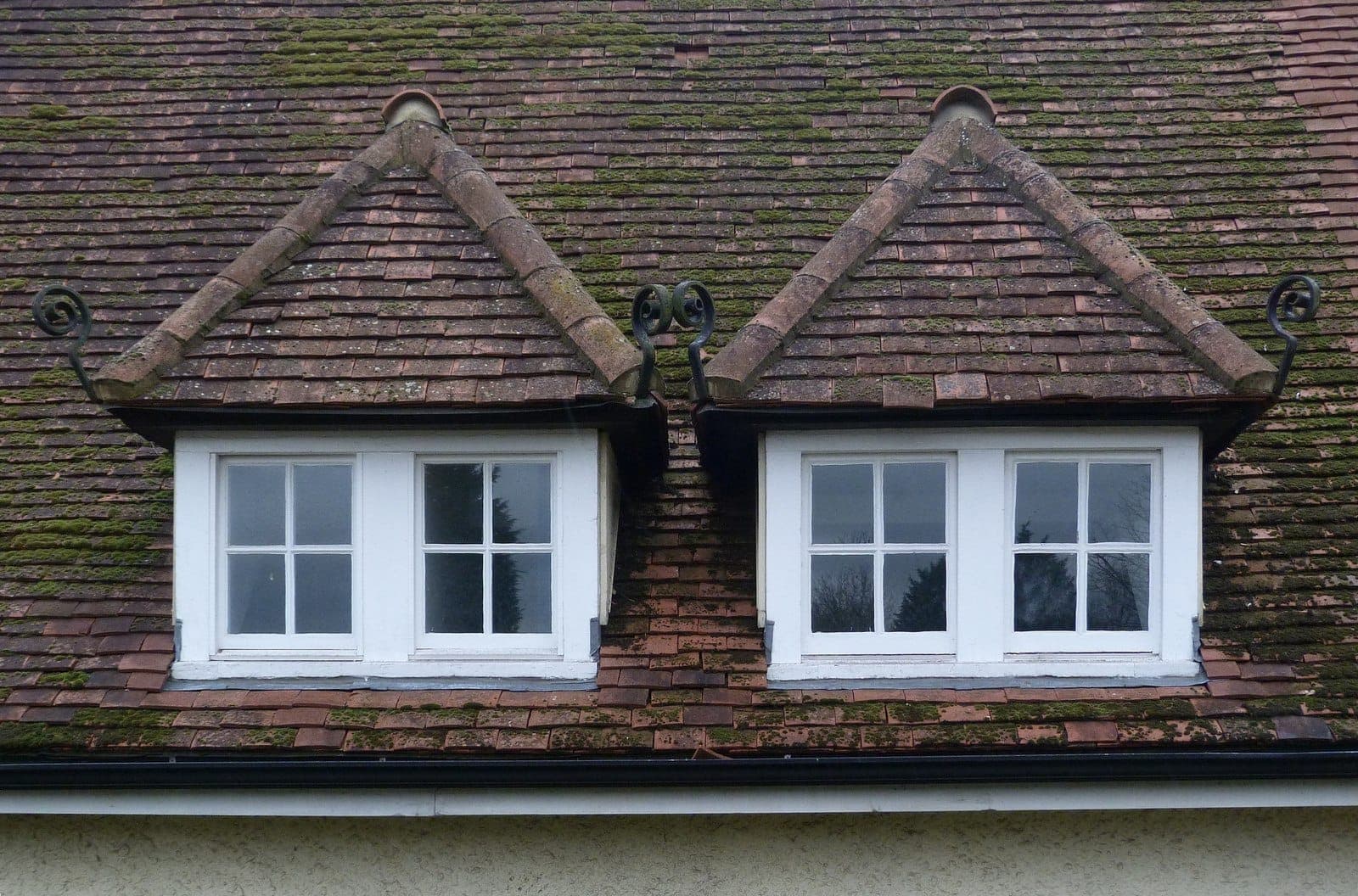 Two pitched-roof dormer windows set side by side in a clay-tiled roof in Letchworth