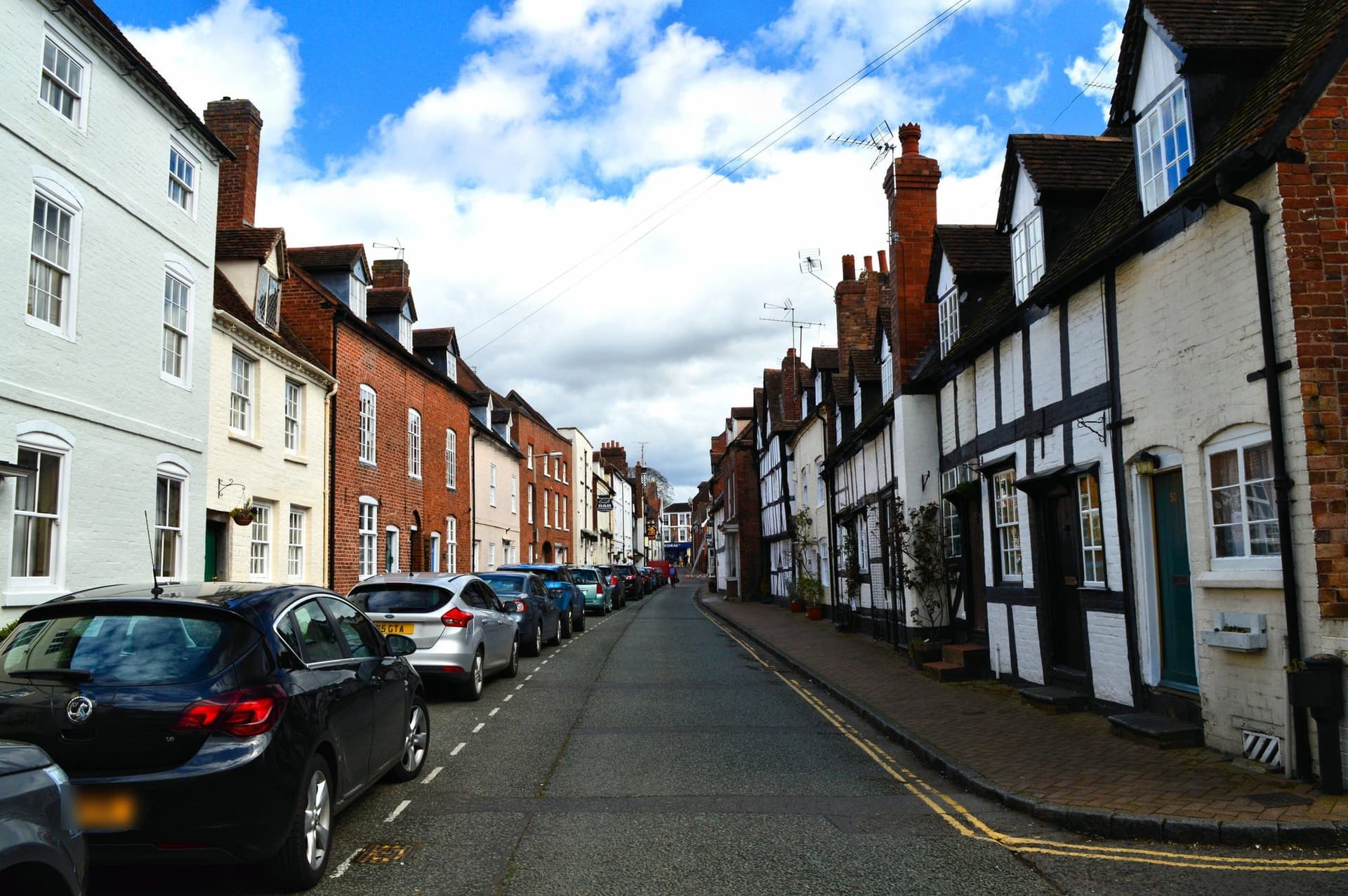 Timber-framed cottages with tiled roofs and small dormers opposite brick and painted town houses on St Mary's Street, Bridgnorth